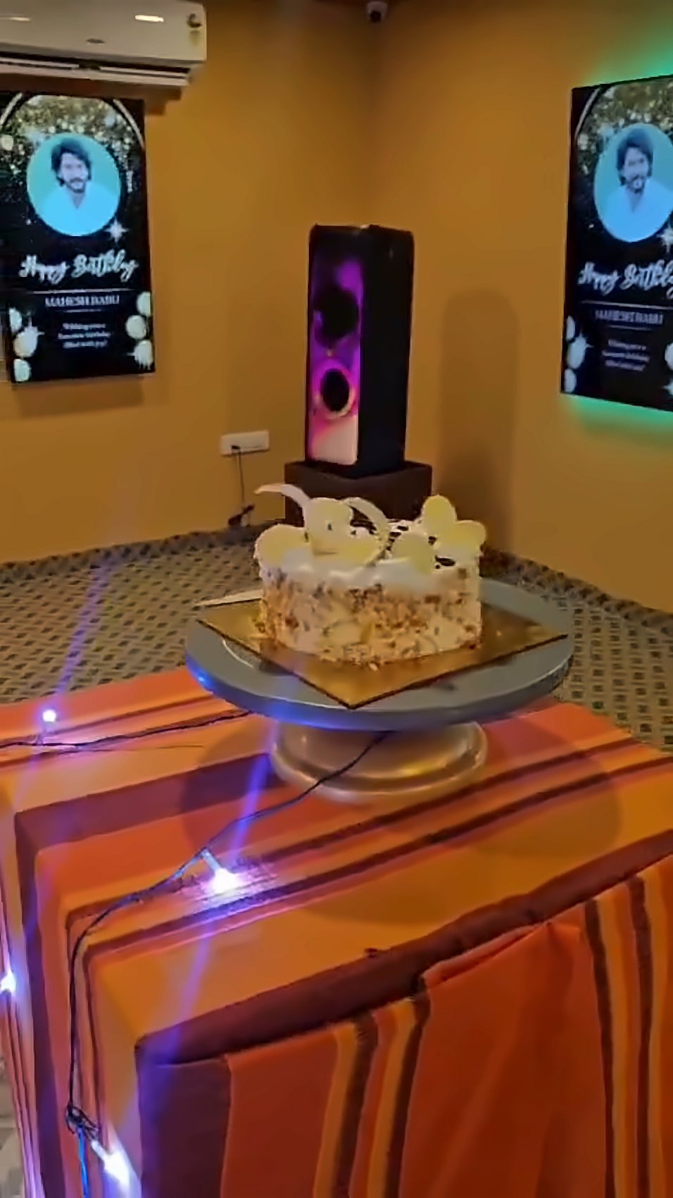 Birthday cake on a lit cake table in the party hall
