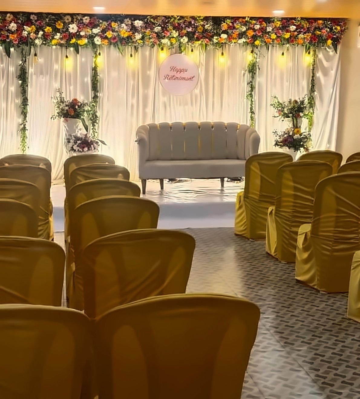Function hall set up for a retirement function — stage with sofa and guest seating
